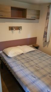 Cama grande en habitación con colchón azul en Camping LE PIGEONNIER en Saint-Crépin-et-Carlucet