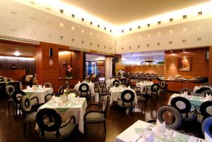 a dining room with white tables and chairs and a restaurant at King's Town Hotel in Kaohsiung