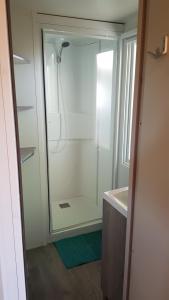 a bathroom with a shower with a glass door at Camping LE PIGEONNIER in Saint-Crépin-et-Carlucet