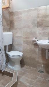 La salle de bains est pourvue de toilettes et d'un lavabo. dans l'établissement TARA INN Resort, à Bastasi