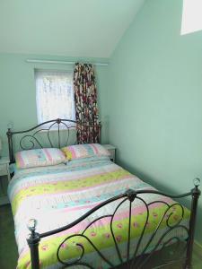 Bett in einem Schlafzimmer mit Fenster in der Unterkunft Little Owls Nest Holiday Home in Wisbech