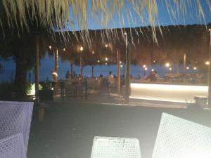 a restaurant with a view of the ocean at night at MADY in Skafidia