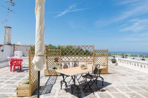 a patio with a table and chairs and the ocean at Sea and the City Apartments by Wonderful Italy in Ostuni