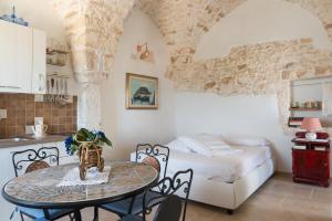 una cucina e una camera da letto con un tavolo e un letto di Sea and the City Apartments by Wonderful Italy a Ostuni