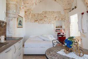 una cucina con letto e tavolo in una camera di Sea and the City Apartments by Wonderful Italy a Ostuni