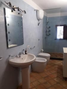 La salle de bains est pourvue d'un lavabo, de toilettes et d'un miroir. dans l'établissement Salina Case Vacanze, à Santa Marina Salina