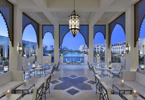 een lobby met tafels en stoelen en een kroonluchter bij Steigenberger Resort Alaya Marsa Alam - Red Sea - Adults Friendly 16 Years Plus in Baai van Coraya