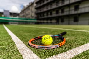 uma bola de ténis e raquete num campo de ténis em ProfilHotels Mercur em Copenhaga