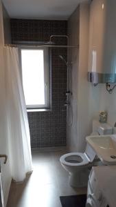 a bathroom with a toilet and a shower and a window at Apartment Adriatic in Makarska