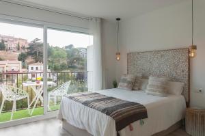 een slaapkamer met een bed en een balkon met een tafel bij Lets Holidays Studio in Tossa in Tossa de Mar