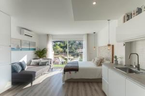 ein Schlafzimmer mit einem Bett und einem Sofa sowie eine Küche in der Unterkunft Lets Holidays Studio in Tossa in Tossa de Mar