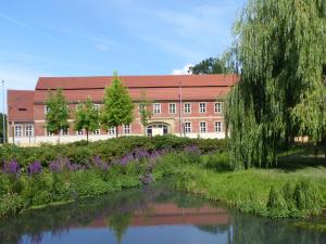 a building with a river in front of a building at Hotel Vierseithof Luckenwalde in Luckenwalde