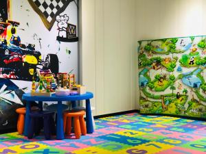 a table and stools in a room with a mural at Fairytale Yi Su Hotspring Hotel in Jiaoxi