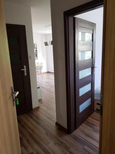 an open door to a room with a wooden floor at Apartament Nad Łomnicą in Karpacz
