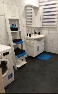 y baño blanco con lavabo y lavadora. en Gleinstraße 24 Wohnung en Sankt Margarethen bei Knittelfeld