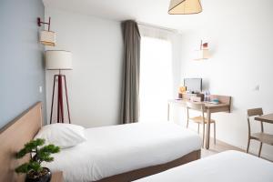 Llit o llits en una habitació de Zenitude Hôtel-Résidences Narbonne Centre