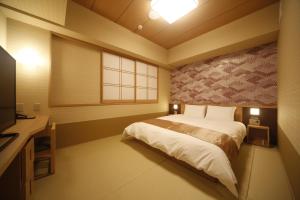 奈良御宿诺诺奈良天然温泉酒店的一间卧室，配有一张床、一张书桌和一台电视