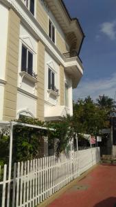 a white fence in front of a white house at Daffodils Spice Court in Cochin
