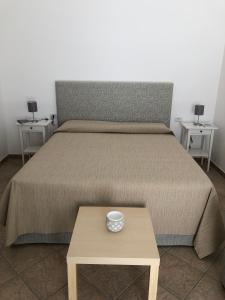 Una cama con una mesa con un tazón. en Corte del Fico en Diso