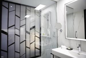 a bathroom with a shower and a sink and a mirror at Riu Plaza España in Madrid