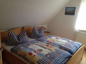 een slaapkamer met een bed met een dekbed en kussens bij Ferienwohnung Kremer in Cuxhaven