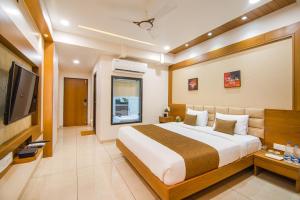 - une chambre avec un grand lit et une télévision dans l'établissement Hotel Sleep Inn, à Uwārsad