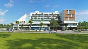 a large building with cars parked in a parking lot at Hotel Sleep Inn in Uwārsad