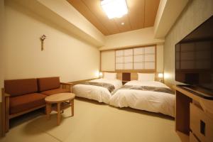 Habitación con 2 camas, sofá y TV. en Onyado Nono Nara Natural Hot Spring, en Nara