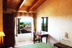 a room with a bed and a desk and a window at Hotel La Pigna in Marina di Pietrasanta