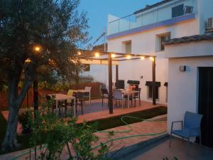 un patio con tavolo e sedie in un cortile di Casa los tejones a Pinos del Valle