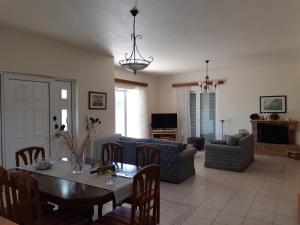 a living room with a table and a couch at Swan House Panoramic View - Near the sea in Zipárion