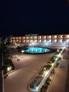 un grande edificio con piscina di notte di Apartamentos Parque Carolina a Costa Del Silencio