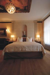 a bedroom with a large bed with a chandelier at HIP Hotel in Heidelberg