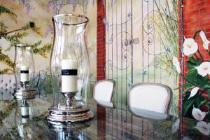 two candles sitting on a table with two glass vases at Hotel La Pigna in Marina di Pietrasanta