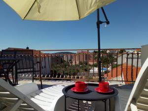 two red hats are sitting on a table on a balcony at Boutique Apartments Julija in Vodice