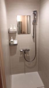 a bathroom with a shower and a mirror at Hills Hotel Gotanda in Tokyo