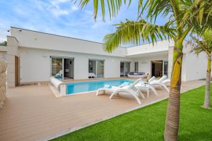 a backyard with a pool and chairs and a house at BestVillas Apúlia Relax in Esposende