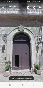 a door on a building with two plants in front at Appartamento storico in pieno centro ad Agnone in Agnone