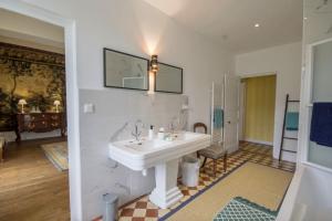 La salle de bains est pourvue d'un lavabo et d'un miroir mural. dans l'établissement Château de Cadouzan, à Saint-Dolay