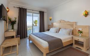 a bedroom with a large bed and a balcony at Zodiac Hôtel & Aqua Park in Hammamet +164 photos