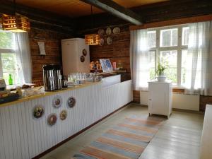 a kitchen with a counter with a refrigerator and windows at Suomela Camping in Kärsämäki