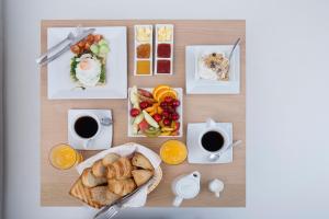 un tavolo con prodotti per la colazione e caffè di May Seven Suites - Adults Only a Megalochori