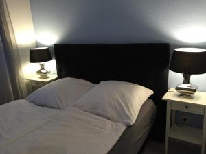 a bedroom with a bed with two lamps on tables at 29 Strandstraße, Wohnung 2 in Baabe