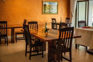 a dining room with a wooden table and chairs at Tinyiko Kruger Lodge in Marloth Park