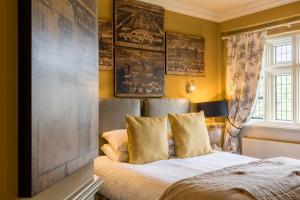 a bedroom with a bed and some pictures on the wall at Coombe Abbey Hotel in Coventry +61 photos