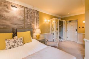 a bedroom with a bed and a table and a chair at Coombe Abbey Hotel in Coventry