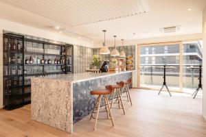 un bar con sgabelli in una stanza con finestra di Hotel Schani Wien Hauptbahnhof a Vienna