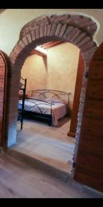 1 dormitorio con 1 cama en un arco de ladrillo en Agriturismo la Tana, en Città di Castello