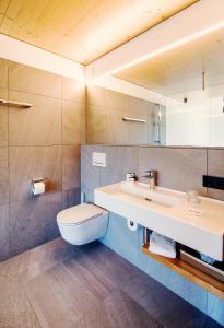 ein Badezimmer mit einem weißen WC und einem Waschbecken in der Unterkunft Hotel Krone in Dornbirn