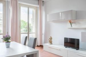 sala de estar blanca con mesa y TV en DonBosco74 Apartment en Roma